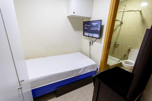 um pequeno quarto com uma cama e uma televisão em Budget Rooms With Private Bathroom for 'girls' only in Dubai, Marina em Dubai