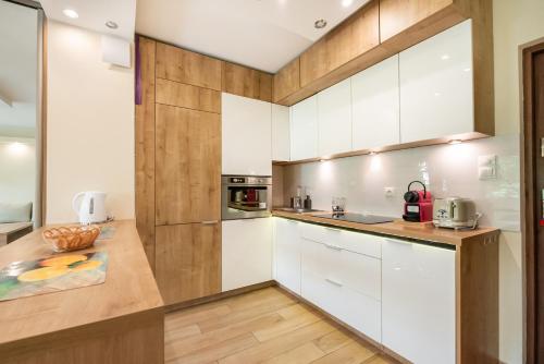 a kitchen with white cabinets and wooden counters at Mokotów Orzycka Beige Studio in Warsaw