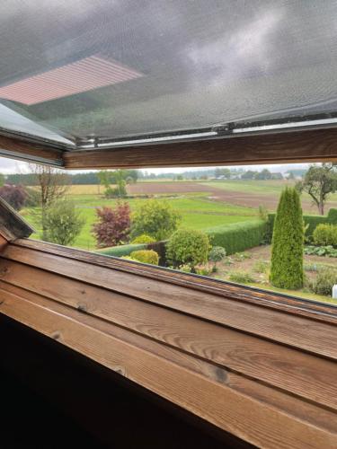 a window with a view of a garden from a house at B&B Des Bois Sans Nombre in Paliseul