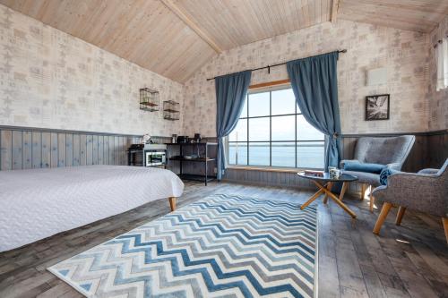 a bedroom with a bed and a table and chairs at Nordic Bliss - KUMA Beach House with Sauna in Käsmu