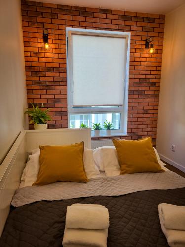 萊格尼察的住宿－Apartament Ceglany，砖墙和窗户的房间里一张床位