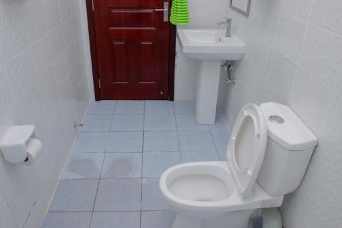 a bathroom with a toilet and a sink at Greatwall Gardens Athiriver in Machakos