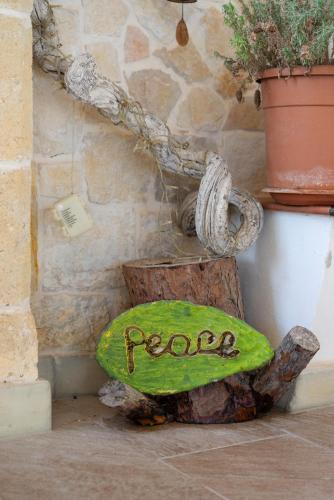 a rock with a sign on it next to a wall at Casa aoom - Casa Vacanze con Sala Yoga e Pilates in San Pietro in Bevagna