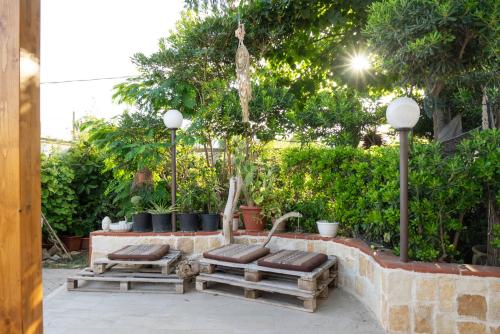a group of benches sitting next to a brick wall at Casa aoom - Casa Vacanze con Sala Yoga e Pilates in San Pietro in Bevagna