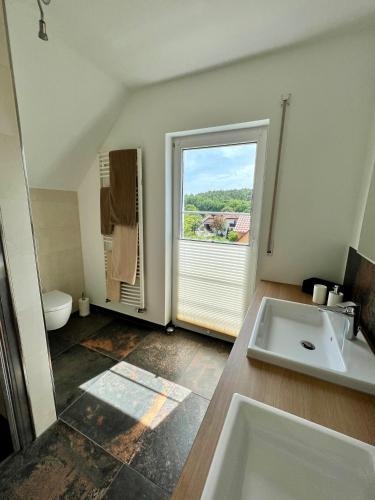 a bathroom with a sink and a window at Ferienwohnung Teichblick in Priesendorf
