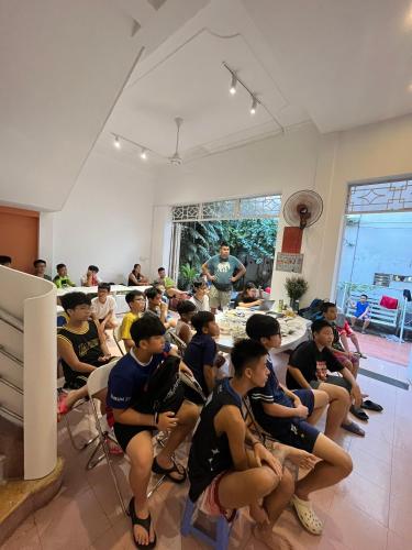 a group of young men sitting in a room at City Hostel Da Nang in Da Nang