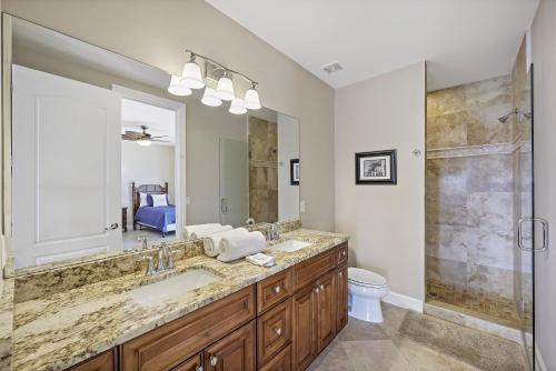 une salle de bain avec un lavabo, des toilettes et un miroir dans l'établissement Opulent waterfront home with pool, spa, dock and deck, à Marco Island