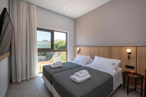 a bedroom with a bed with two towels on it at Villa Manu Luxury Living in Stalos
