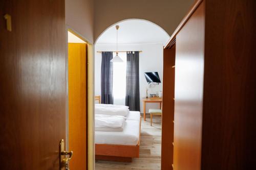 a bedroom with a bed and a room with a door at Drexl Gasthof Shiro in Schondorf am Ammersee