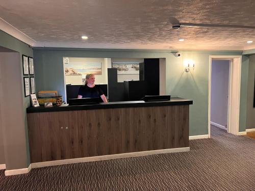 a woman sitting at a reception desk in a office at South Lawn Hotel in Lymington