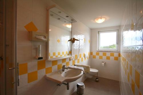 a bathroom with a sink and a mirror at Hotel-Restaurant am Hochfuchs in Eugendorf