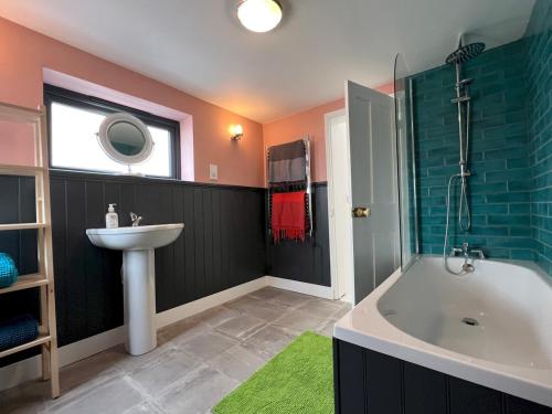 a bathroom with a sink and a bath tub and a sink at Sea Haven Stylish Beach Oasis - Pass the Keys in Hastings