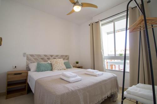 Un dormitorio blanco con una cama con toallas. en Vistamarina B308 By IVI Real Estate, en Torremolinos