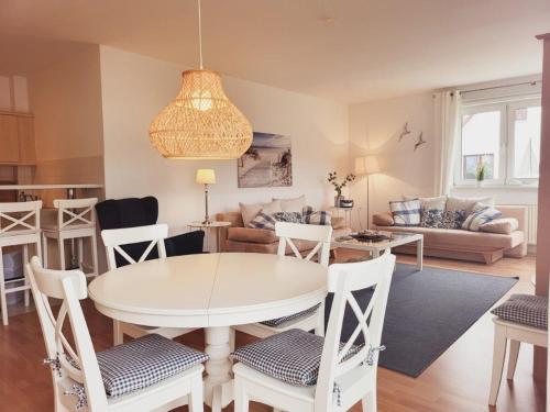 ein Esszimmer und ein Wohnzimmer mit einem Tisch und Stühlen in der Unterkunft Appartementhaus Ulmenhof in Kühlungsborn