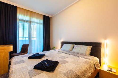 a bedroom with a bed with two robes on it at Burgas Residence 809 in Burgas City