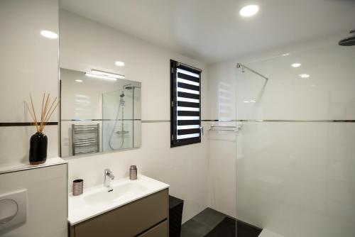 une salle de bain blanche avec un lavabo et une douche dans l'établissement Domaine d'Arca Porto-Vecchio T3 6 pers 