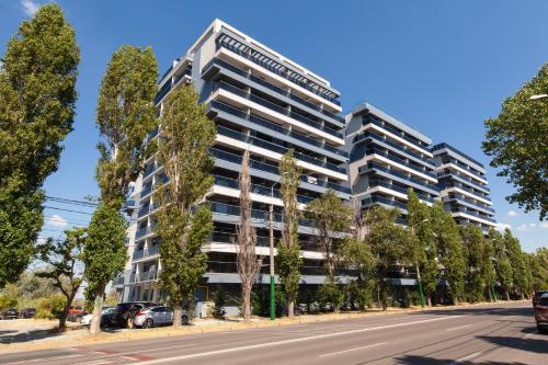 ein Apartmenthaus in einer Straße mit Bäumen in der Unterkunft Aparthotel Mirage Sunset - zona Hotel Rex in Mamaia