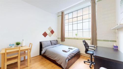 倫敦的住宿－Stunning Studio N7，一间小卧室,配有一张床、一张书桌和一张书桌