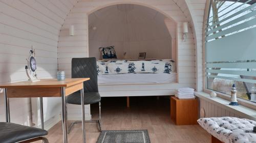 Cette chambre comprend un lit avec un bureau et une chaise. dans l'établissement Tiny Haus 1, à Gützkow