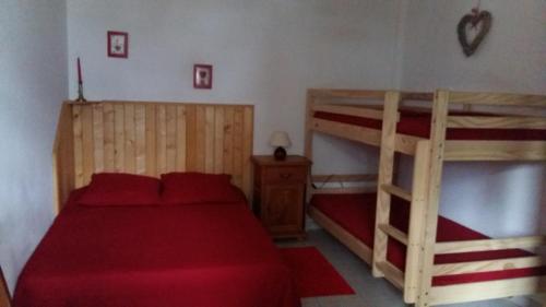 a bedroom with two bunk beds with red sheets at Appartement chalet 4 pers 45m2 Puy Saint Vincent in Puy-Saint-Vincent