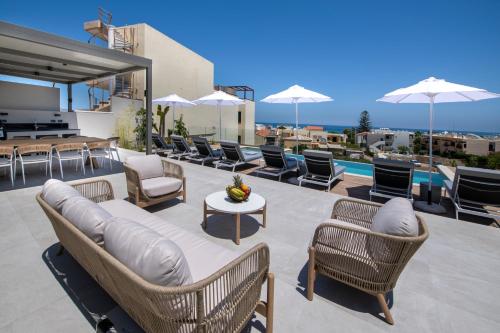 a patio with chairs and a couch and a table at Villa Manu Luxury Living in Stalos