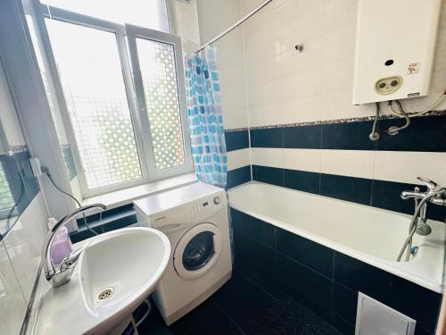 a bathroom with a washing machine and a sink at Гостевой дом на Культуры in Kharkiv