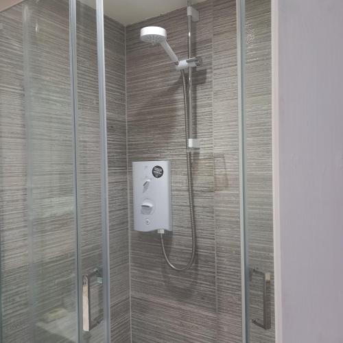 y baño con ducha y puerta de cristal. en Beautiful self-contained annex/Cottage, en Hoylake