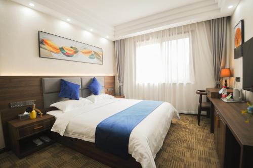Chongqing Jianfeng Hotel في Fuling: غرفة فندقية بسرير كبير ونافذة