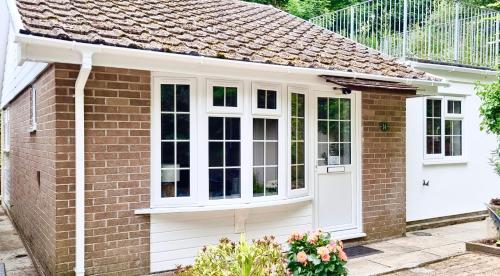a extension to a brick house with white doors at 14 Granite Henge in Looe