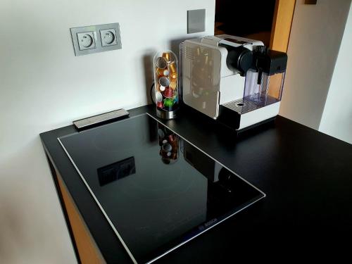 a black counter top with a coffee maker on it at Pláž Hrdlička in Buš