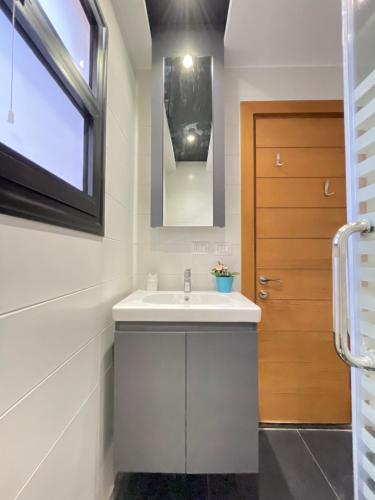 La salle de bains est pourvue d'un lavabo et d'une porte en bois. dans l'établissement Madinaty Stylish furnished 1 bedroom Apartment-شقة فندقيه للايجار مدينتي, à Madinaty