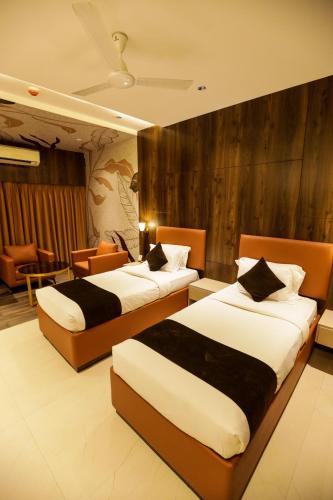 a hotel room with two beds in a room at Hotel Atithi, Aurangabad in Aurangabad