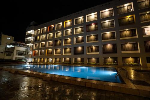 a building with a swimming pool at night at Hotel Atithi, Aurangabad in Aurangabad