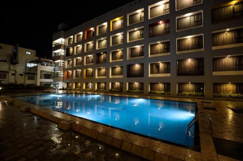 a hotel with a swimming pool at night at Hotel Atithi, Aurangabad in Aurangabad