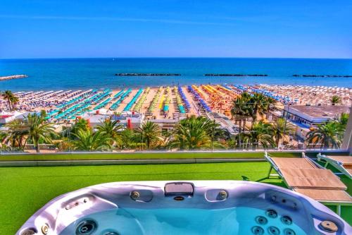 uma vista para uma praia com uma piscina em Hotel Arlecchino em San Benedetto del Tronto