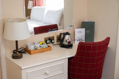 a room with a table with a lamp and a bed at Millers Hotel by Greene King Inns in Sibson