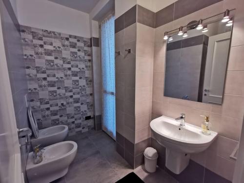 y baño con lavabo, aseo y espejo. en Appartamento - La Bella Italia, en Canelli