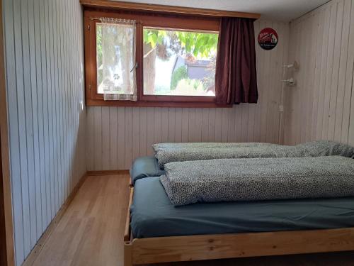 Kleines Zimmer mit einem Bett und einem Fenster in der Unterkunft Studio indépendant en résidence avec extérieur in Portalban- Dessous
