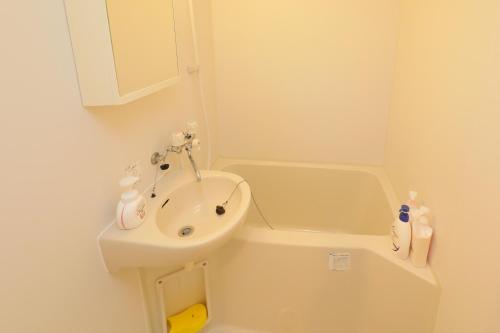 a bathroom with a sink and a toilet and a tub at Casa Matsubara in Tokyo