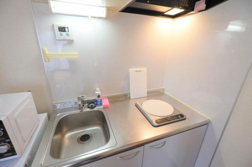 a small bathroom with a sink and a toilet at Casa Matsubara in Tokyo