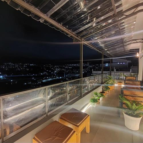 a balcony with benches and a view of the city at Cafe Sola bnb in Shillong