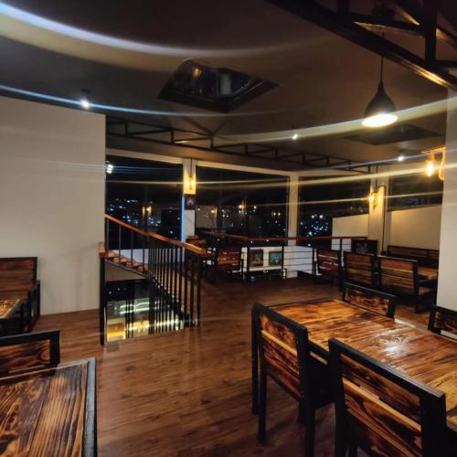 a restaurant with wooden tables and benches and a view of the city at Cafe Sola bnb in Shillong