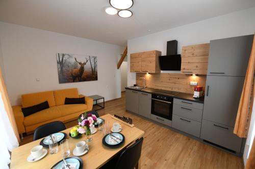Una cocina y una sala de estar con una mesa y un sofá. en Ferienapartments 31erHaus, en Hieflau