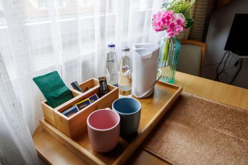 un vassoio con tazze e un vaso su un tavolo di Drexl Gasthof Shiro a Schondorf am Ammersee