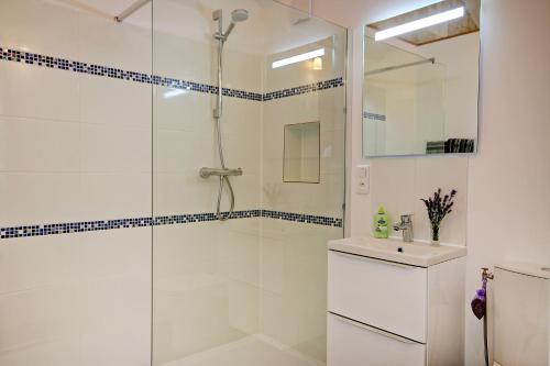 a white bathroom with a shower and a sink at La Maronniere in Challignac