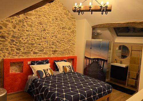 a bedroom with a bed and a stone wall at Suzy Home 2 in Moisenay