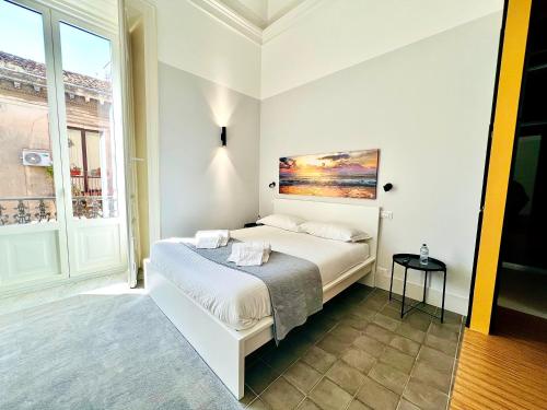 een slaapkamer met een bed met een schilderij aan de muur bij Ruanera in Catania