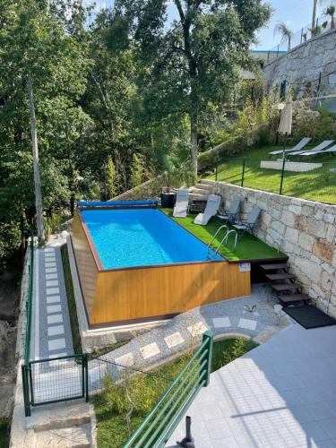 a swimming pool in a yard next to a stone wall at Estrela do Geres in Geres