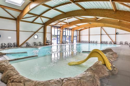 a swimming pool with a slide in the water at Camping maeva Club l'Atlantique in Angles