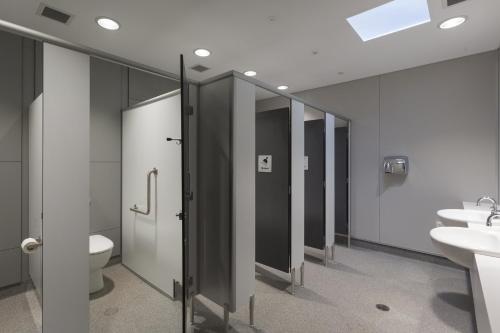 ein Bad mit einem WC, 2 Waschbecken und Spiegeln in der Unterkunft Fremantle Prison YHA in Fremantle